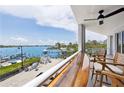 Balcony overlooking harbor, furnished with chairs and ceiling fan at 516 Tamiami S Trl # 306, Nokomis, FL 34275