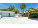 Spacious backyard with a basketball court, covered seating area, two-car garage, and lush landscaping at 5238 Susan Ave, Sarasota, FL 34231