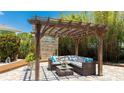 Cozy outdoor seating area under a pergola with string lights and stylish furniture surrounded by lush greenery at 5238 Susan Ave, Sarasota, FL 34231