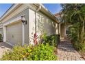 Home's exterior showcasing lush landscaping, a brick walkway, and neutral color palette at 5418 Fairfield Blvd, Bradenton, FL 34203