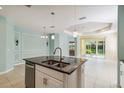 Open kitchen and living area with a granite island, tile flooring, and stainless steel appliances at 5418 Fairfield Blvd, Bradenton, FL 34203