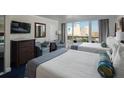 Comfortable bedroom featuring two queen beds, a dresser, sitting area, and a balcony view at 5500 Gulf Blvd # 6248, St Petersburg, FL 33706