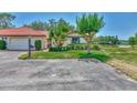 Beautiful home with a red tile roof, lush lawn, mature landscaping, and proximity to a serene pond at 5651 Golf Pointe Dr # 5651, Sarasota, FL 34243