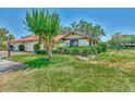 Charming single-story home with a red tile roof, well-manicured lawn, mature landscaping, and attached two-car garage at 5651 Golf Pointe Dr # 5651, Sarasota, FL 34243