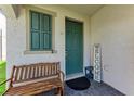 Inviting front porch with a wooden bench and a 'Welcome' sign next to the teal door at 5735 Bungalow Grove Ct, Palmetto, FL 34221