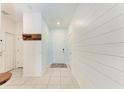 Bright hallway with modern shiplap walls and stylish tile flooring, with white doors on each side at 5735 Bungalow Grove Ct, Palmetto, FL 34221