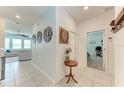 Open hallway featuring elegant tile flooring, access to multiple rooms, and decorative wall art at 5735 Bungalow Grove Ct, Palmetto, FL 34221