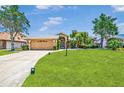 Well-manicured front yard featuring a lush green lawn and mature landscaping surrounding a single-story home at 5742 39Th Street E Cir, Bradenton, FL 34203
