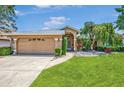 Charming single-story home featuring a well-maintained lawn, a two-car garage, and mature landscaping at 5742 39Th Street E Cir, Bradenton, FL 34203