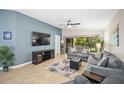 Bright living room with comfortable gray sofas, a large TV, and sliding glass doors opening to the lanai at 5866 Guarino Dr, Sarasota, FL 34238