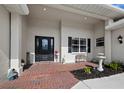 Welcoming front porch with brick flooring, a decorative fountain, and a charming seating area at 6643 Butlers Crest Dr, Bradenton, FL 34203
