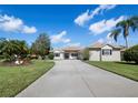 Charming home featuring a well-manicured lawn and a long driveway leading to the attached garage at 6643 Butlers Crest Dr, Bradenton, FL 34203