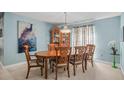 Elegant dining room features a chandelier, hutch, and a large painting on the wall at 7804 Broadmoor Pines Blvd, Sarasota, FL 34243