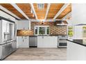 Bright kitchen featuring stainless steel appliances, geometric backsplash, and modern white cabinets at 8234 Midnight Pass Rd, Sarasota, FL 34242