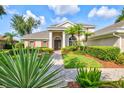 Attractive home with a stone walkway, verdant landscaping, and a well-maintained lawn at 8930 Bloomfield Blvd, Sarasota, FL 34238