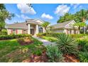 Inviting home showcasing manicured landscaping, a stone walkway, and a welcoming front entrance at 8930 Bloomfield Blvd, Sarasota, FL 34238