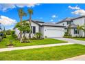 Beautiful single-Gathering home with a well-maintained lawn, paver driveway, and tropical landscaping at 10868 Sun Drop St, Venice, FL 34293