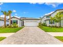 Charming single Gathering home featuring a two-car garage, well-manicured lawn and tropical landscaping at 10868 Sun Drop St, Venice, FL 34293