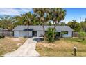 Charming single-story home with a one car garage and lush palm trees in the front yard at 112 E Marland Ct, Nokomis, FL 34275