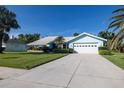 Charming single-story home featuring a well-manicured lawn, two-car garage, and bright blue exterior paint at 1279 Vermeer Dr, Nokomis, FL 34275