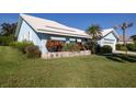 A light-blue home with a tiled roof and well-kept landscaping, complemented by a green lawn at 1279 Vermeer Dr, Nokomis, FL 34275