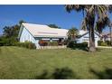 Charming one-story light-blue home surrounded by a well-maintained lawn and tropical foliage at 1279 Vermeer Dr, Nokomis, FL 34275