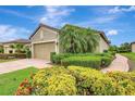 Charming single-story home featuring a red tile roof, two-car garage, and colorful landscaping at 13108 Torresina Ter, Bradenton, FL 34211