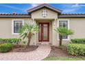 Inviting front entrance with a brick walkway, decorative front door, lush landscaping and a modern design at 13108 Torresina Ter, Bradenton, FL 34211