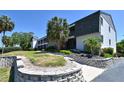 Exterior view of the condo building featuring well-maintained landscaping, a walkway, and attractive architectural details at 2124 N Tamiami Trl # 108, Sarasota, FL 34234