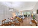 Bright living room with modern furnishings, dining area, and sliding glass doors to the balcony at 2124 N Tamiami Trl # 108, Sarasota, FL 34234