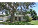 Lovely single-story home featuring a well-manicured lawn and mature trees shading the property at 2475 Wood Oak Dr, Sarasota, FL 34232