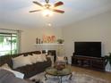 Cozy living room featuring a decorative fireplace, plush sofa, and a large-screen television at 2475 Wood Oak Dr, Sarasota, FL 34232