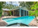Backyard pool with a screened in lanai and tropical foliage at 2630 Bucida Dr, Sarasota, FL 34232