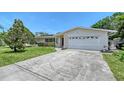 Single-story home featuring an attached garage, a well-manicured lawn, and mature landscaping at 3127 Dawson St, Sarasota, FL 34239