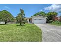 Well-kept lawn, mature trees, and a charming single-story home with attached garage at 3127 Dawson St, Sarasota, FL 34239