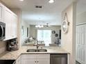 Stylish kitchen with white cabinetry, stainless steel appliances, and a clear view into the living area at 396 Countryside Key Blvd, Oldsmar, FL 34677