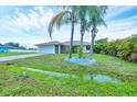 Lovely single-story home with a two-car garage, complemented by lush landscaping and mature palm trees at 408 Fletcher St, Port Charlotte, FL 33954
