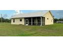Back of the home showcasing a screened-in porch and spacious yard at 4353 Hidden River Rd, Sarasota, FL 34240