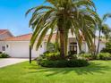 Charming single-story home with a well-manicured lawn, mature palm trees, and a white garage door, offering classic curb appeal at 4492 Del Sol Blvd, Sarasota, FL 34243