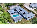Aerial view of a home with a pool, deck, solar panels and a well-manicured lawn at 4771 Riverwood Cir, Sarasota, FL 34231