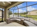 Inviting screened patio with comfortable wicker seating and serene lake views at 4833 San Palermo Dr, Bradenton, FL 34208