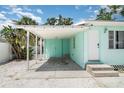 Exterior shot of a home featuring a covered carport and a white front door at 5026 Calle Minorga, Sarasota, FL 34242