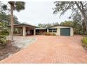Spacious home with a brick driveway, covered parking, and a detached garage at 5353 Shadow Lawn Dr, Sarasota, FL 34242