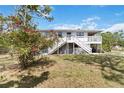 A charming home featuring a staircase leading to a spacious deck and well-maintained yard at 5403 Fleming St, Port Charlotte, FL 33981