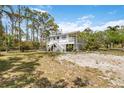 A charming home featuring a staircase leading to a spacious deck and well-maintained yard at 5403 Fleming St, Port Charlotte, FL 33981
