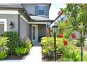 Inviting front porch with lush landscaping, an American flag, and a charming light post at 5475 Summit Gln, Bradenton, FL 34203