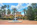 Beautiful clubhouse featuring a fountain, red tile roof, and surrounded by palm trees at 5711 Bentgrass Dr # 19-203, Sarasota, FL 34235