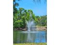 Picturesque fountain nestled within a serene pond surrounded by lush greenery at 5711 Bentgrass Dr # 19-203, Sarasota, FL 34235