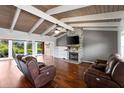 Inviting living room featuring a stone fireplace, wood-beamed ceilings, and expansive views of the waterfront at 6406 Lincoln Rd, Bradenton, FL 34203