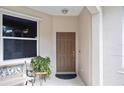 Covered front porch with bench seating and a wooden front door at 8224 Simpson Falls Ct # 8224, Sarasota, FL 34243